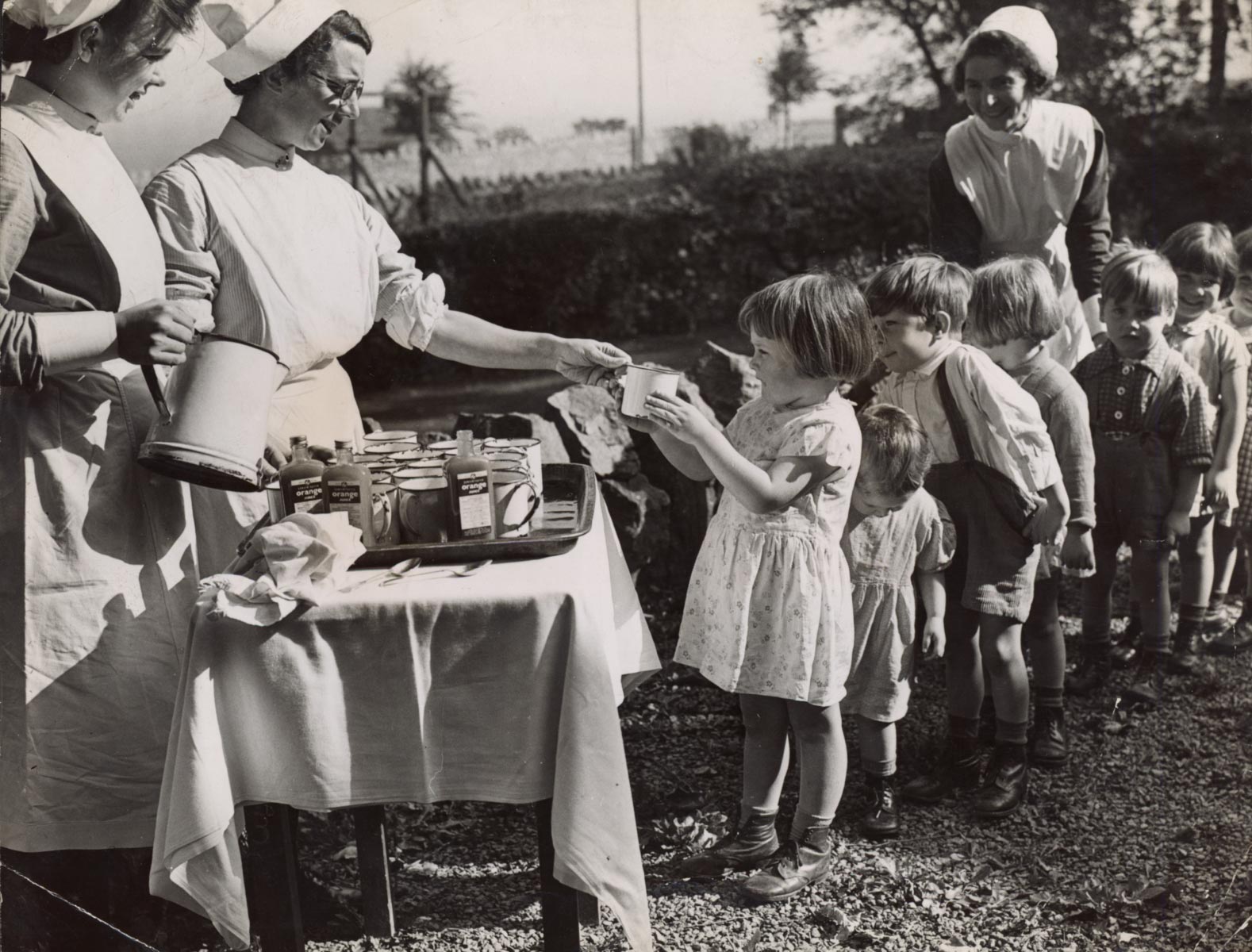 Image of children queueing up for orange juice