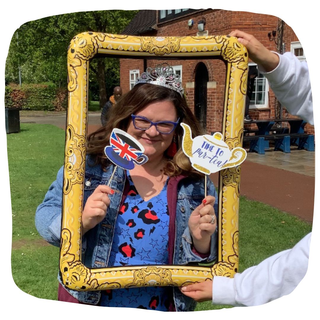 Staff member posing for a photo at the photo booth frame