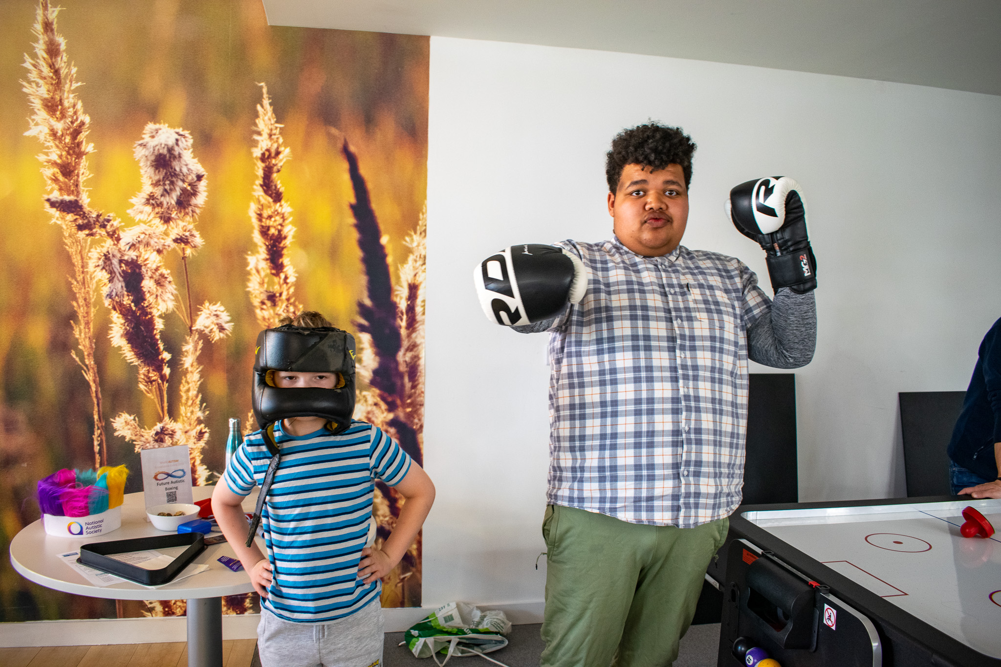 Mason and Alfie, 2 inscape students, posing for the camera wearing boxing gloves and helmet.