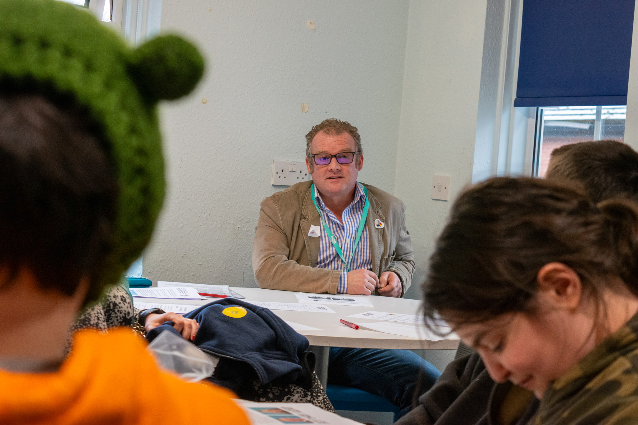 The silhouette of two students listening to a man in the background talk to them. 