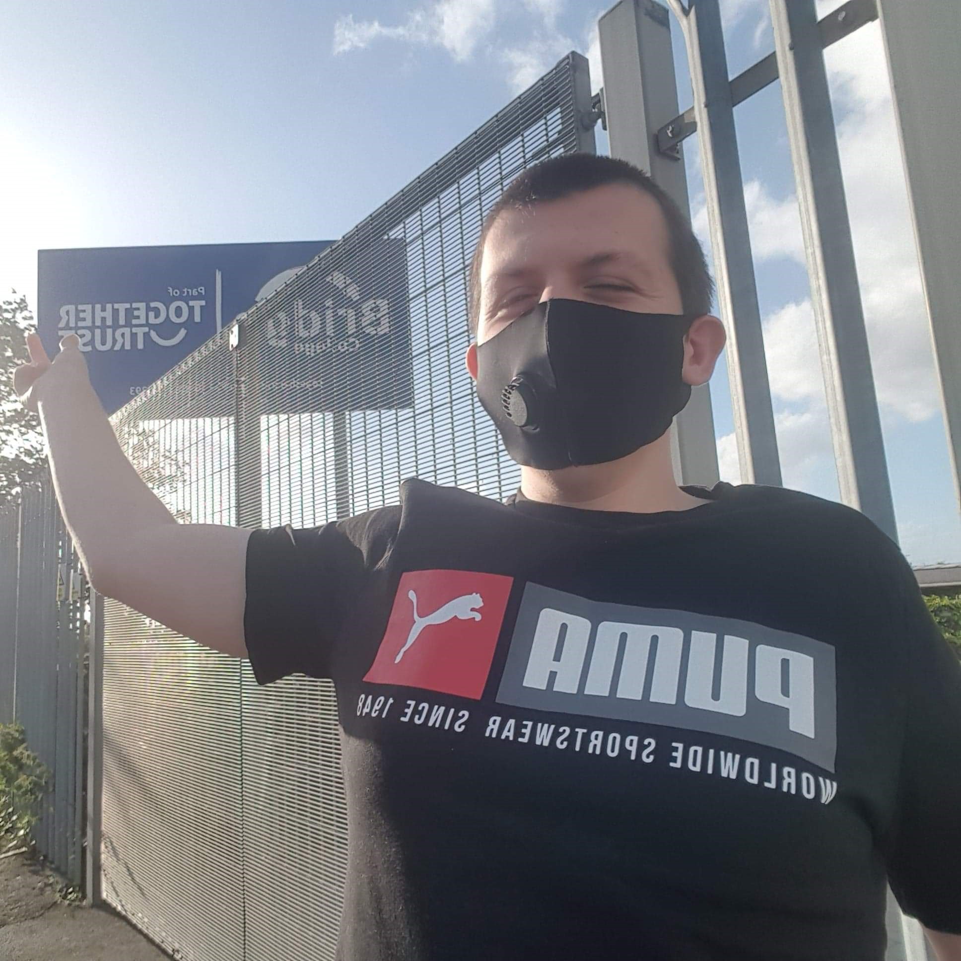 Liam: “Another joyous picture, this time about missing college.” Paul Coates A photo of Liam outside Bridge College pointing at the sign. He is wearing a face mask.
