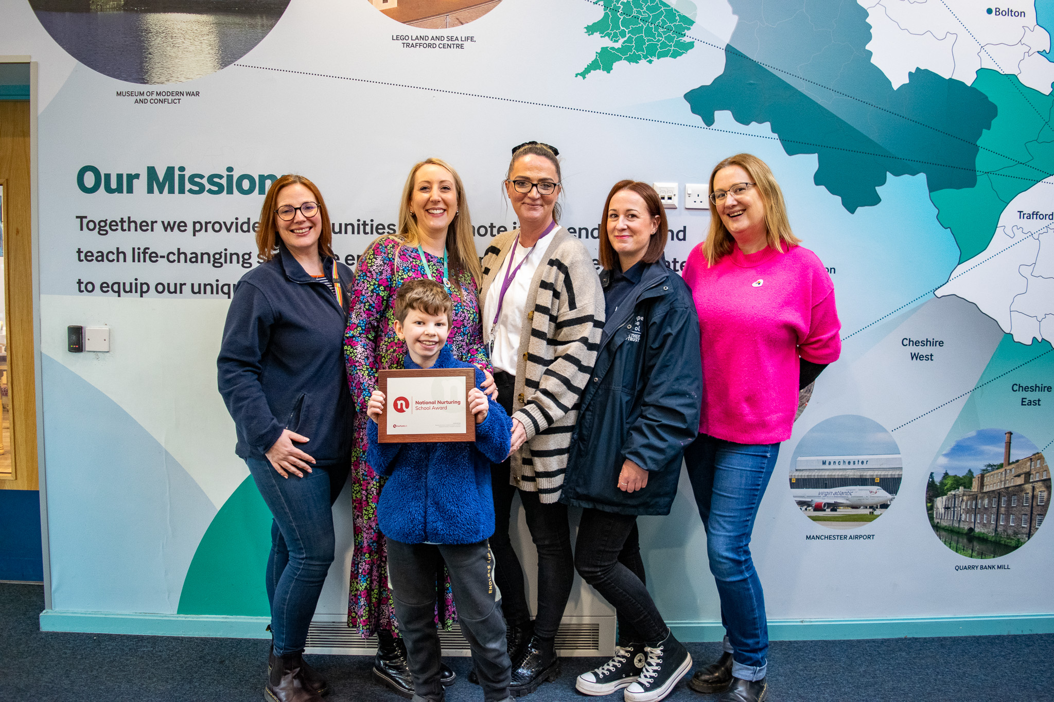 The Nurture team and a pupil, holding the Award certificate and posing for a photo