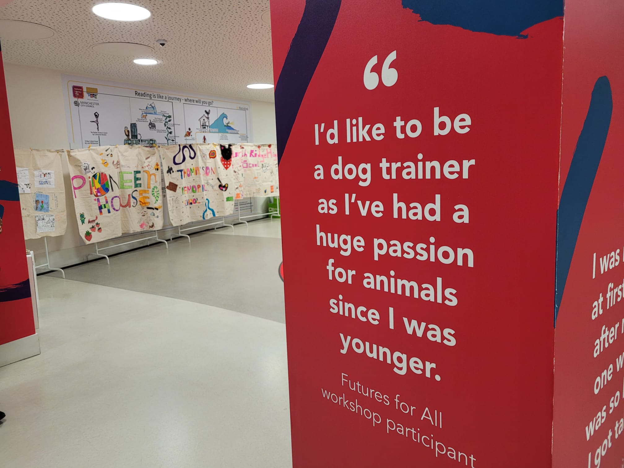 Mutiple textile panels displaying art from young people. In front of them a pillar with text that reads "I'd like to be a dog trainer as I've had a huge passion for animals since I was younger"