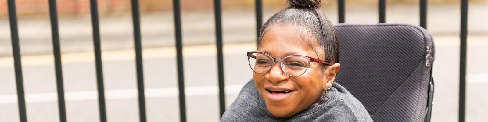 Young woman in a wheelchair smiling into the distance