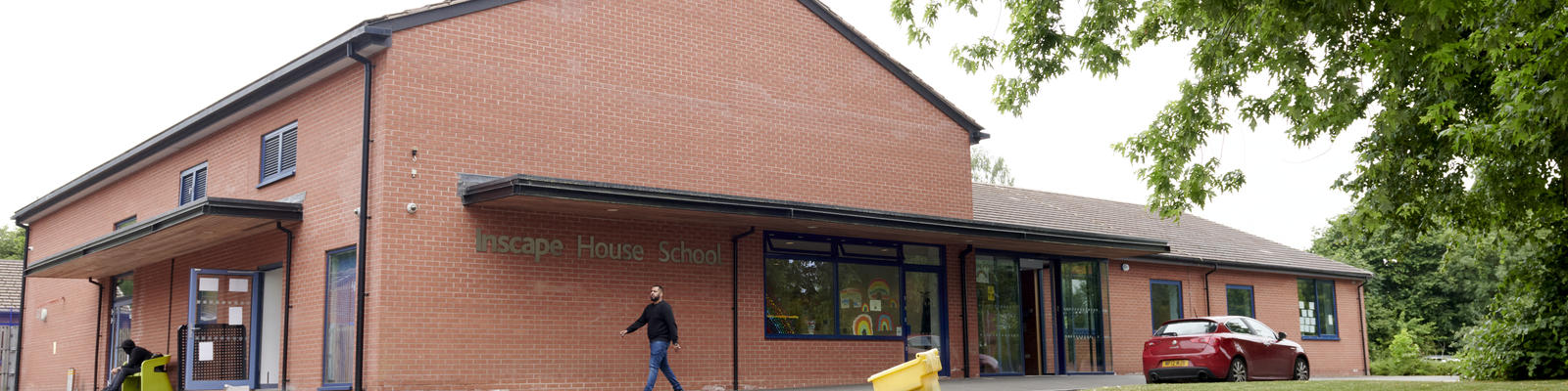 The front of inscape school with a member of staff walking in front