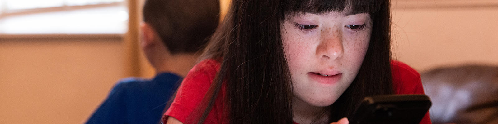 Young girl looking down at a mobile phone