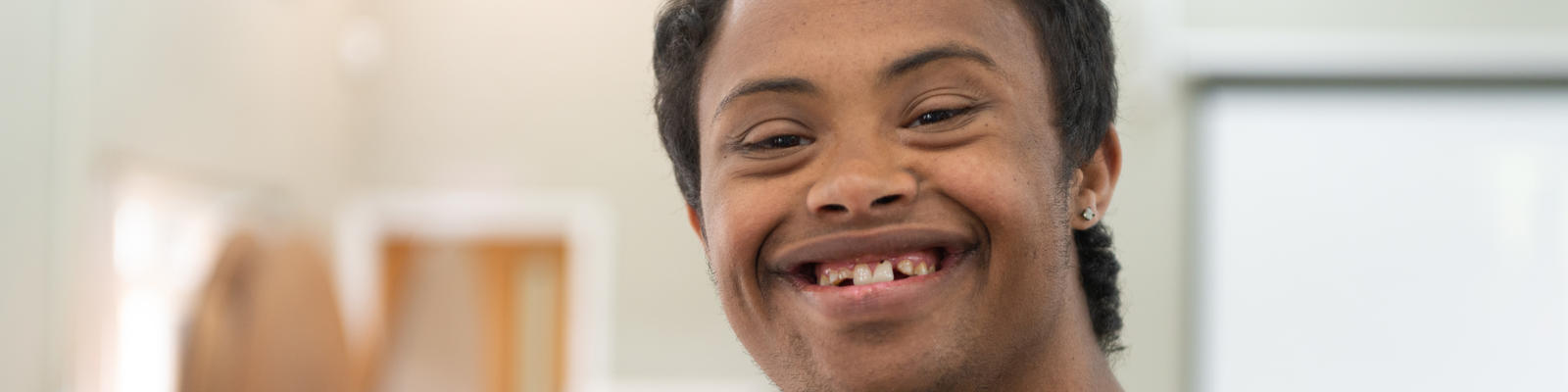 Young man with down syndrome smiling wide at the camera