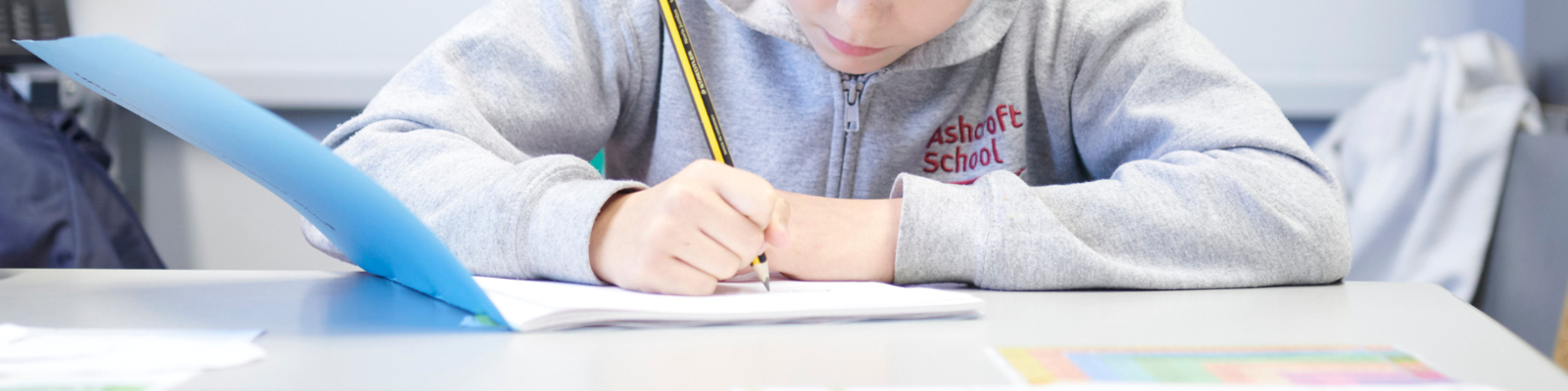 Young person writing in a workbook in school 