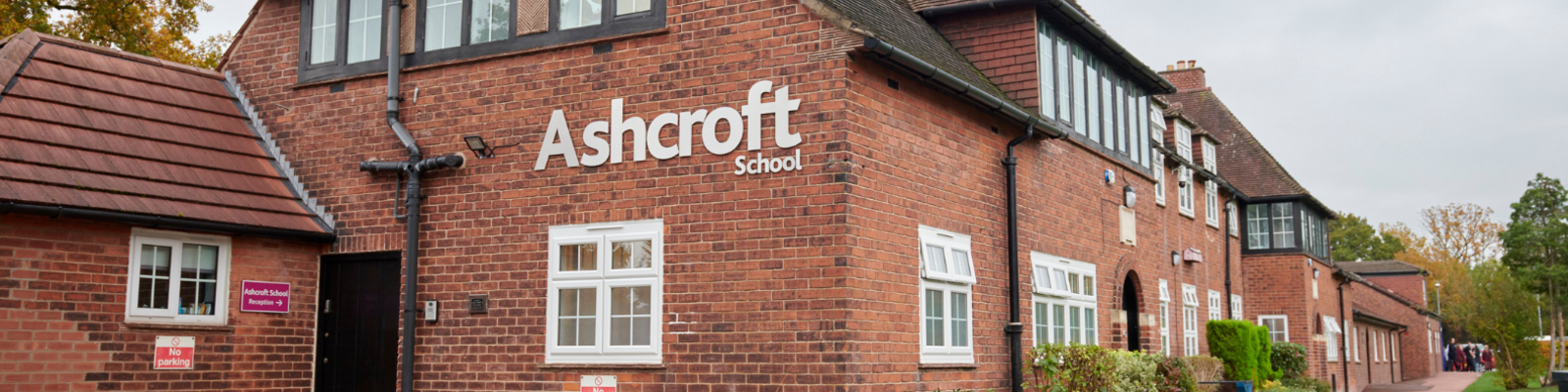 Large red brick building with sign that reads "Ashcroft school"