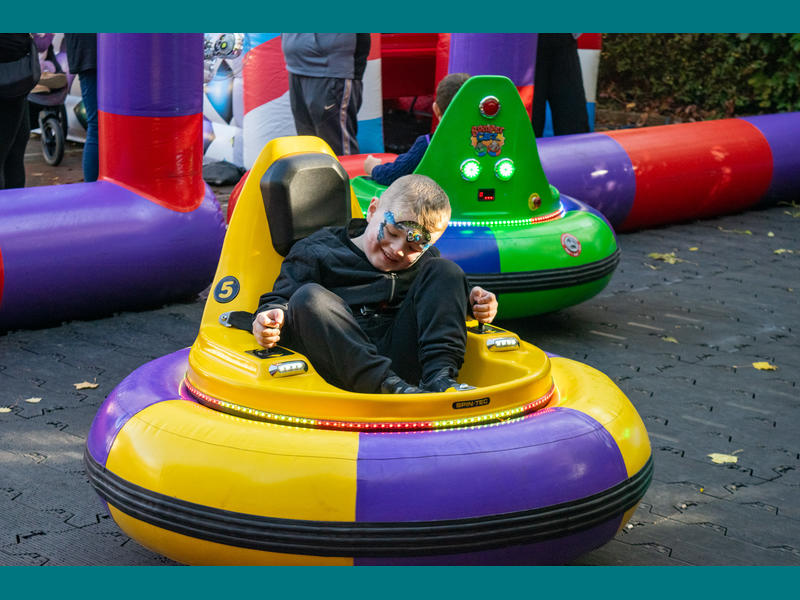 Boy wearing face paint smiling in the bumper cars.