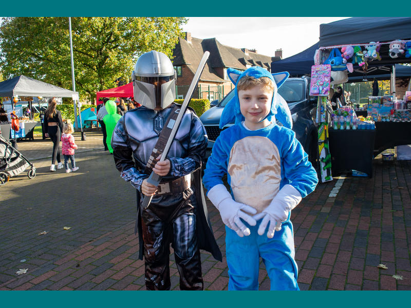 Two young boys in fancy dress smiling - one as the Mandalorian and one as Sonic the Hedgehog.