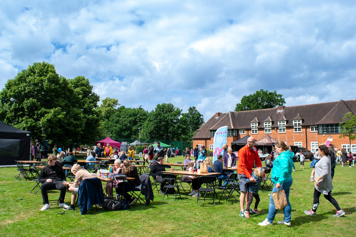 a group of people sat on the grass at join together festival