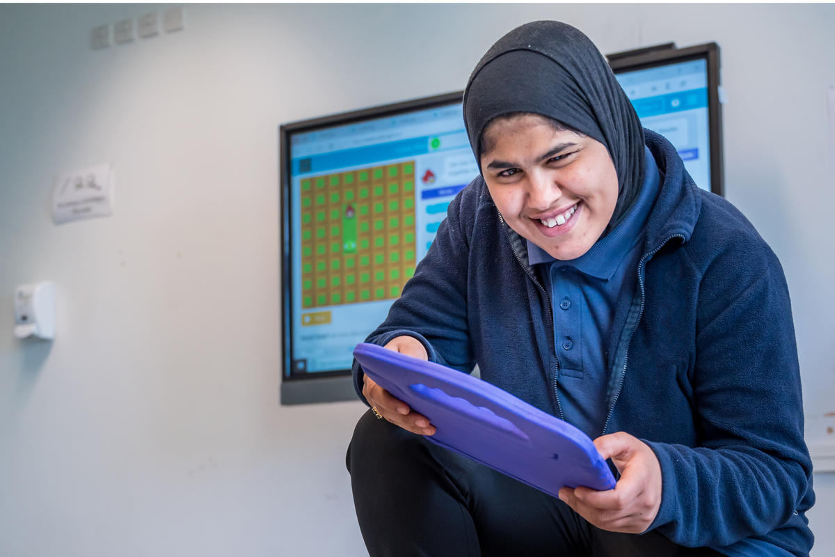 A Bridge College student with an ipad, enjoying school time