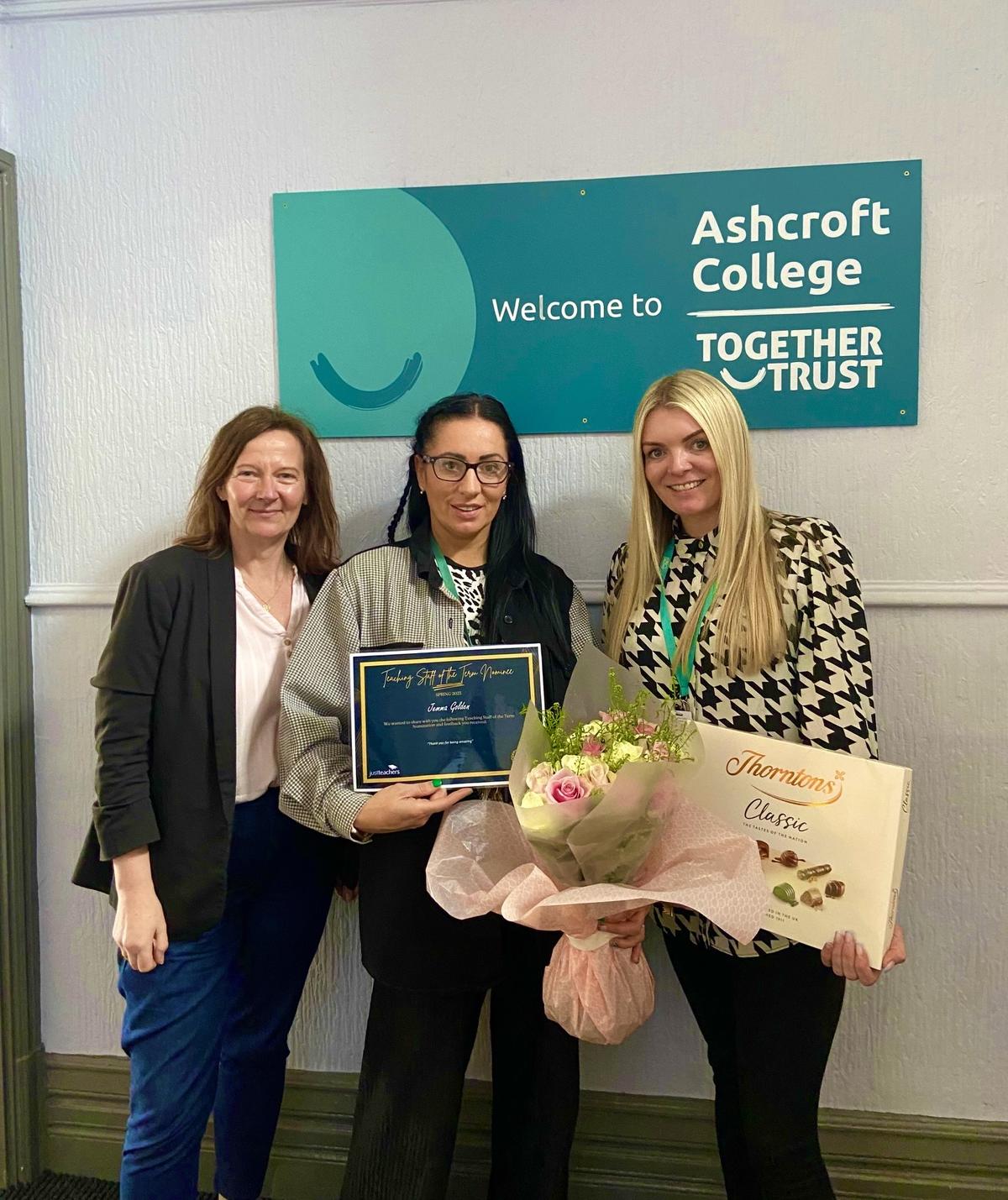 Image shows Jane Embury, Operations Manager at Justteachers, Jemma Golden, holding her certificate, a box of chocolates and flowers, and Leigh Fleming, Pastoral Lead at Ashcroft College