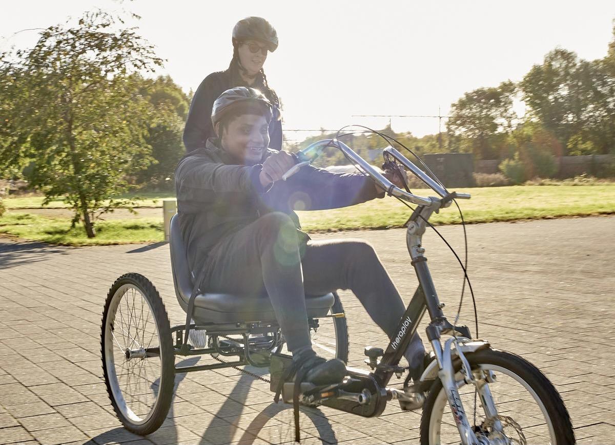 A photo of a student and staff on bikes.