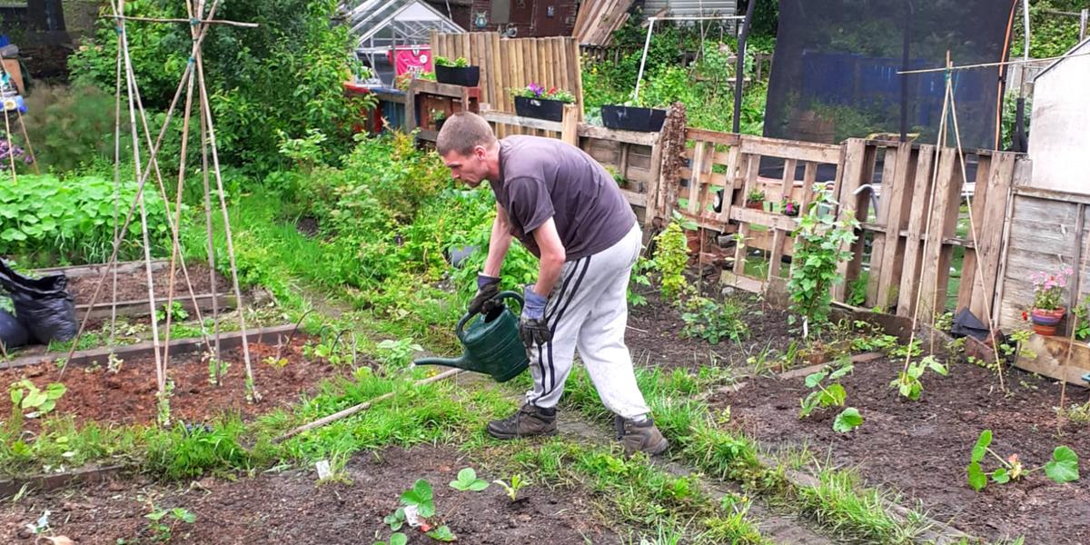 The young person's dad watering the garden