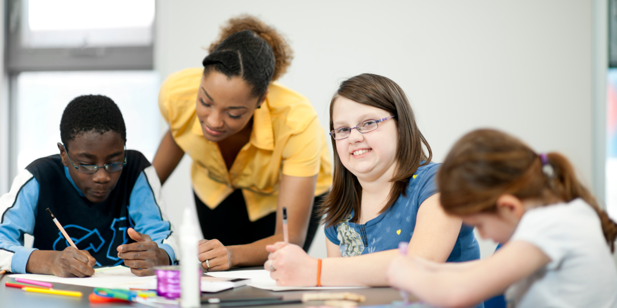 A teacher and three students in a classroom