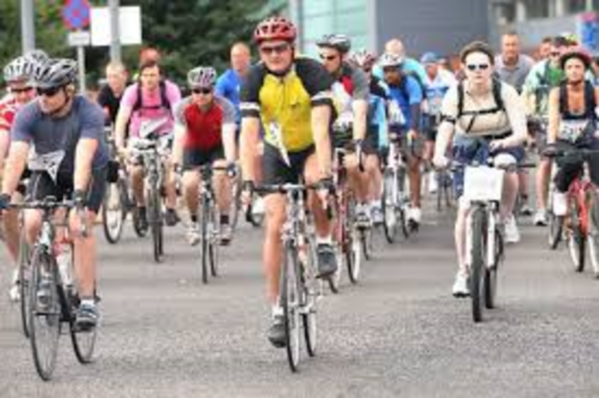 A group of cyclists in brightly coloured shirts riding towards the camera A group of cyclists in brightly coloured shirts riding towards the camera