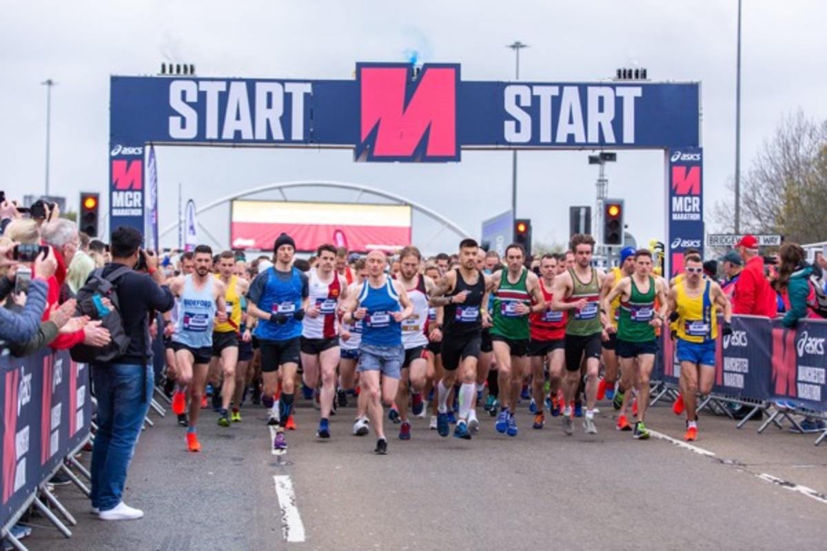 A group of runners setting off on the Manchester marathon in brightly coloured shirts