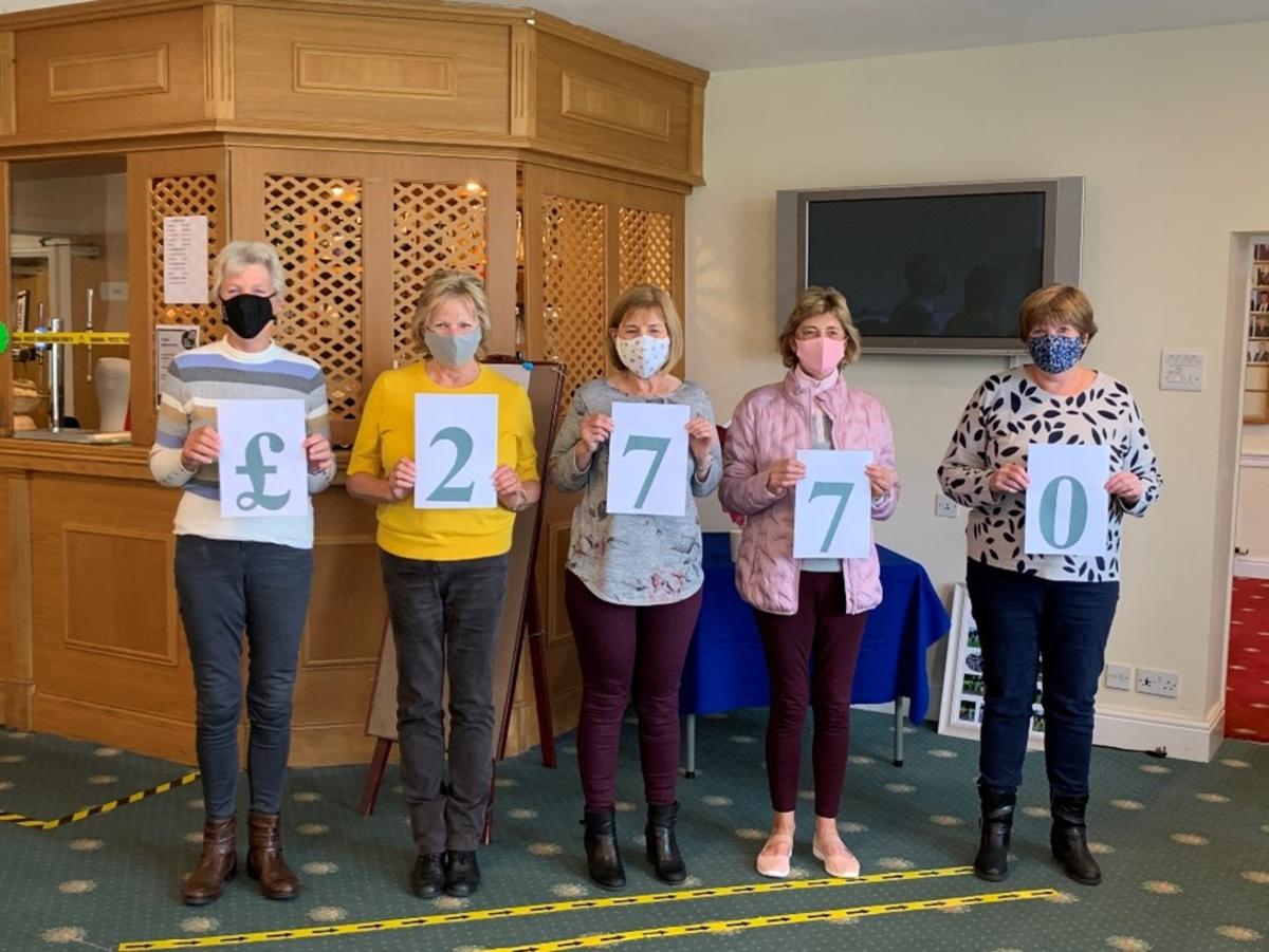 Members of Marple Golf club holding up the total that they raised in numbers Members of Marple Golf club holding up the total that they raised in numbers