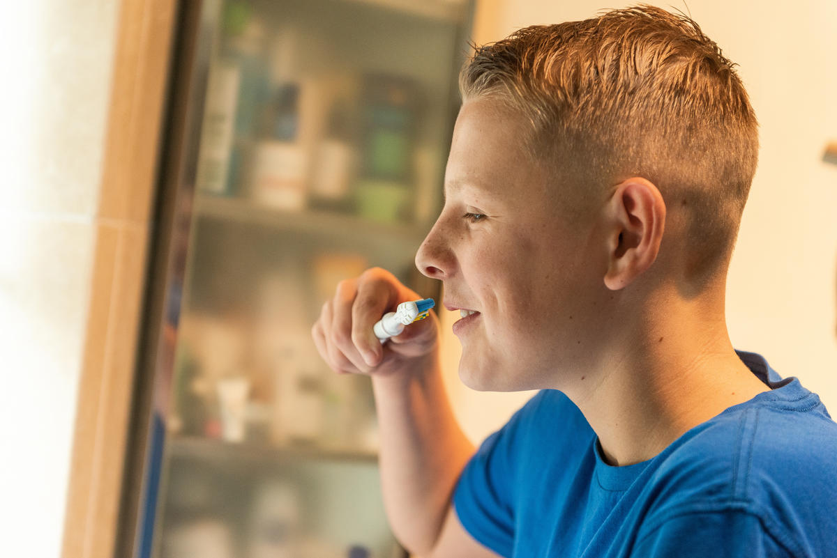 A boy in the bathroom brushing his teeth