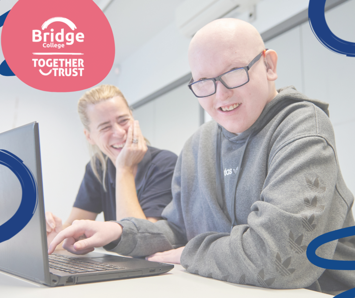 a photo of a student working at a laptop with their support worker