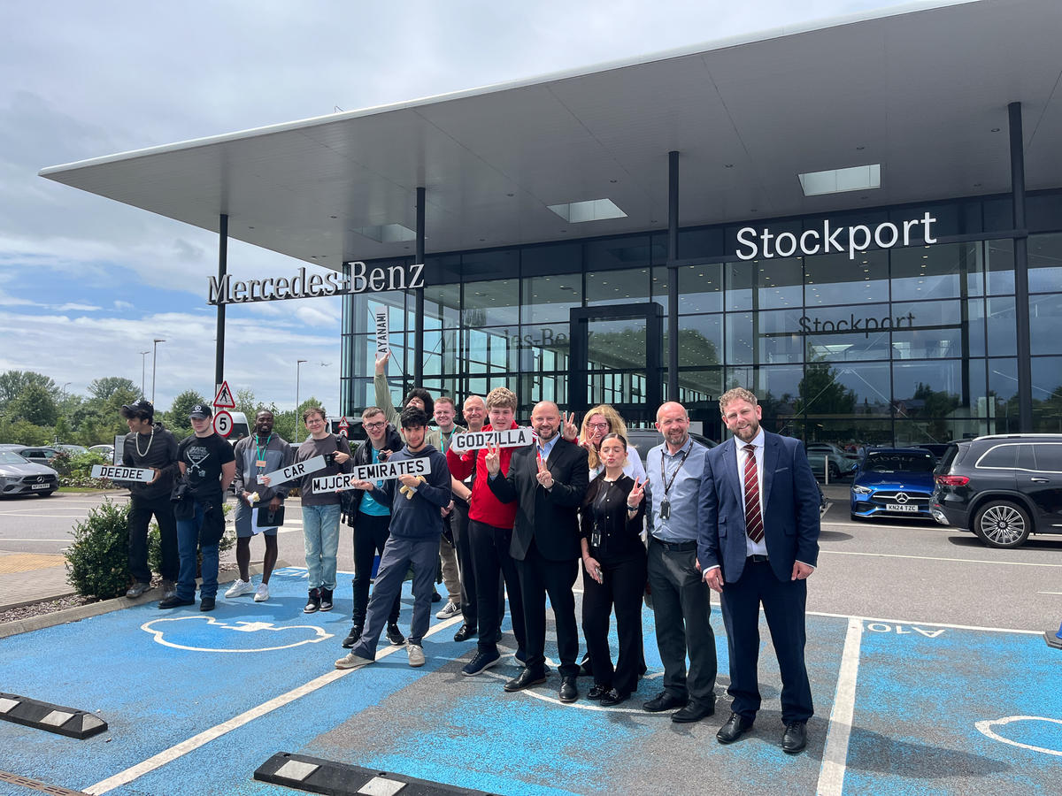 A large group of students and staff members from Mercedes posing in front of the building