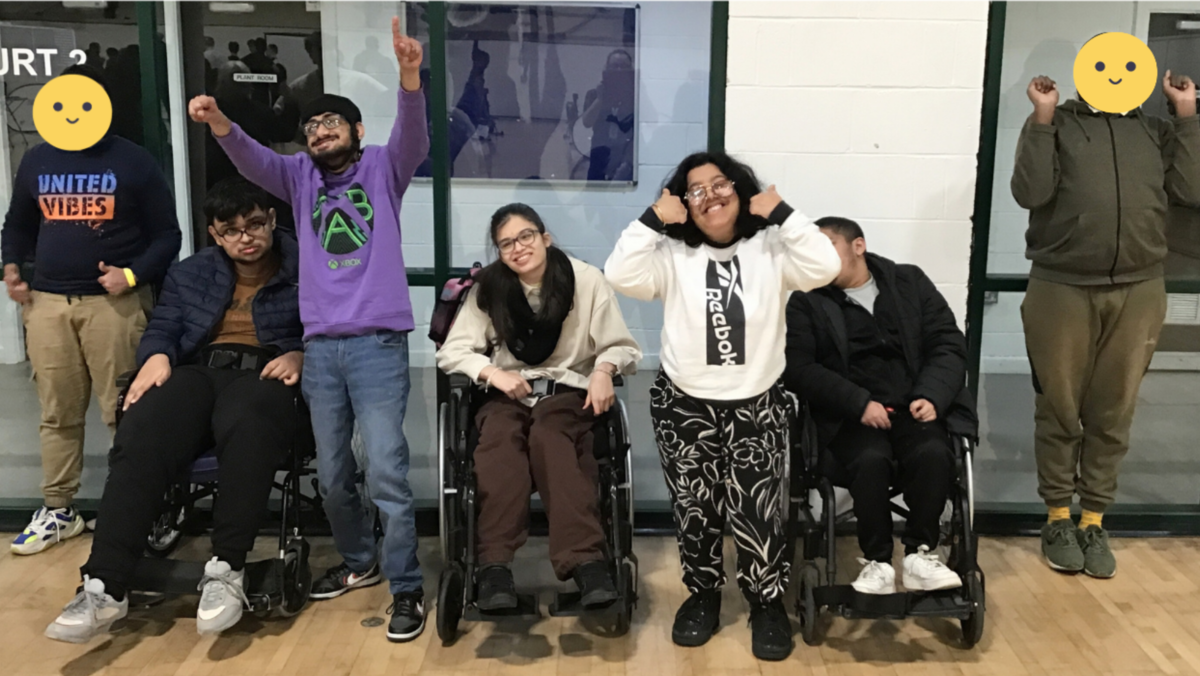 A photo of students that participated in the rowing competition smiling and waving their arms in the air