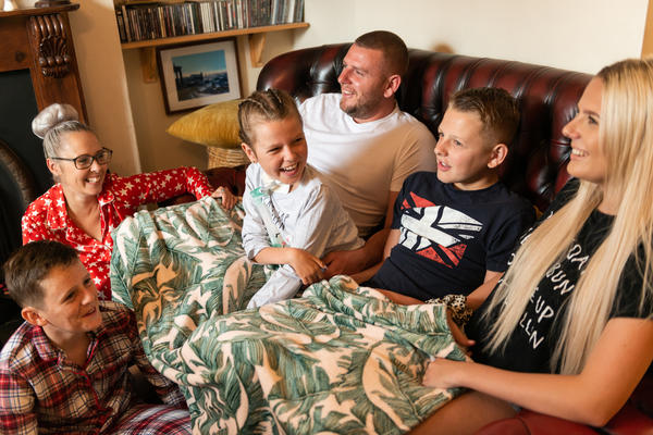 A family sat together on the sofa