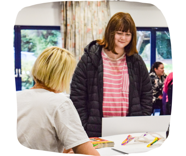 Young girl talking to woman at a careers fair. 