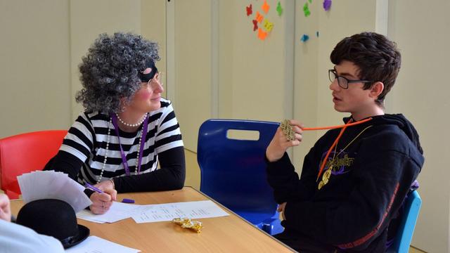 A teacher dressed as Gangsta Granny chatting with a student.