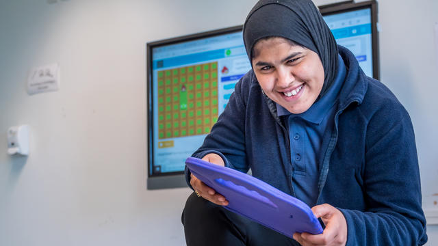 A Bridge College student with an ipad, enjoying school time