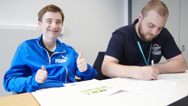 a bridge student smiling at the camera