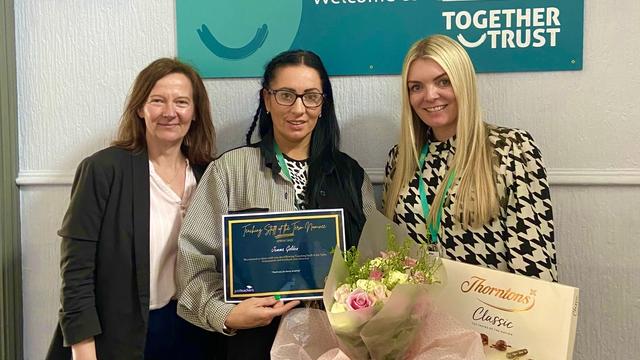 Image shows Jane Embury, Operations Manager at Justteachers, Jemma Golden, holding her certificate, a box of chocolates and flowers, and Leigh Fleming, Pastoral Lead at Ashcroft College