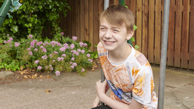 A student sat on a swing smiling