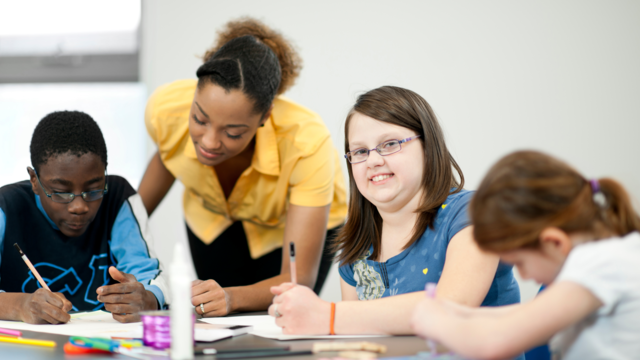 A teacher and three students in a classroom