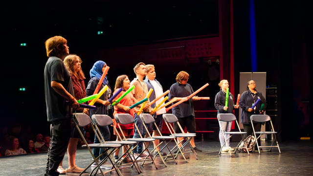 A group of students and teachers on the stage.