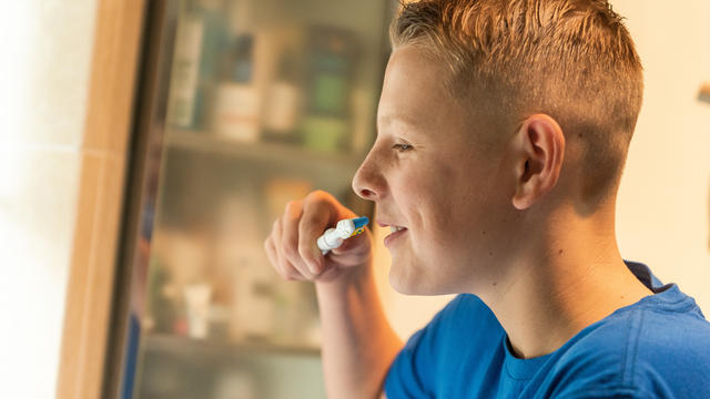 A boy in the bathroom brushing his teeth