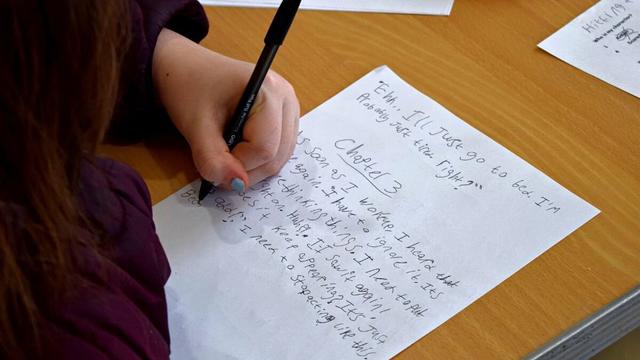 A photo showing the hand of a student while she's writing up chapter three of her story