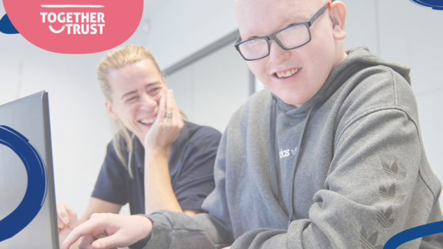 a photo of a student working at a laptop with their support worker