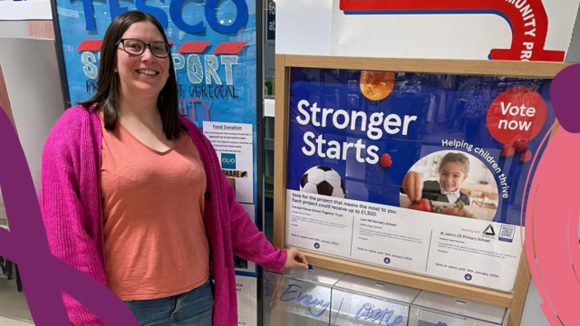 Woman holding a blue token pointing towards the voting box that reads "Together Trust"