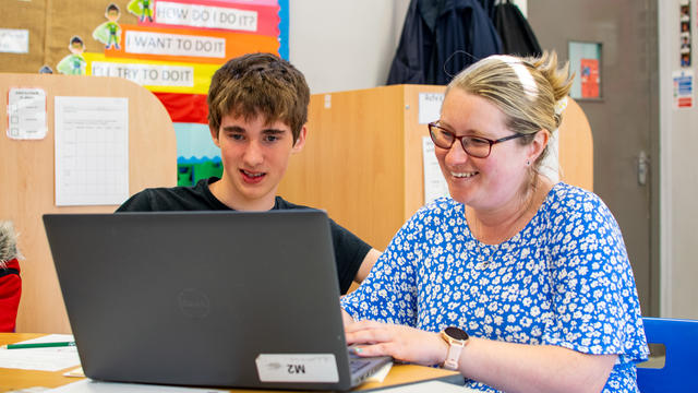 Inscape 2025 - student and staff smiling at desk, looking at computer