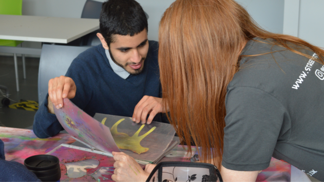 Student is picking a stencil they'd like to use with the help of Sissy from Street Style Surgery