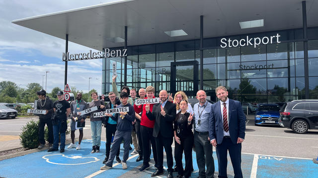 A large group of students and staff members from Mercedes posing in front of the building