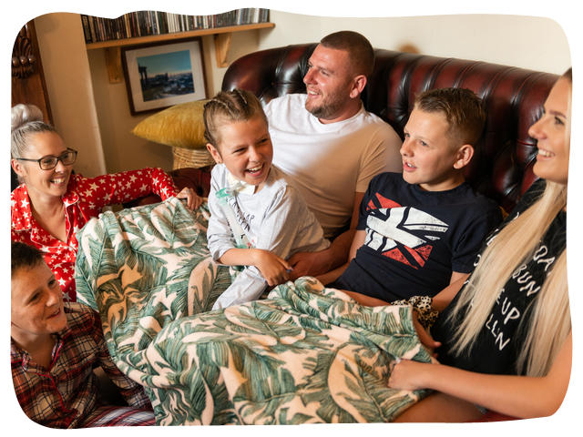 A family sat together on the sofa