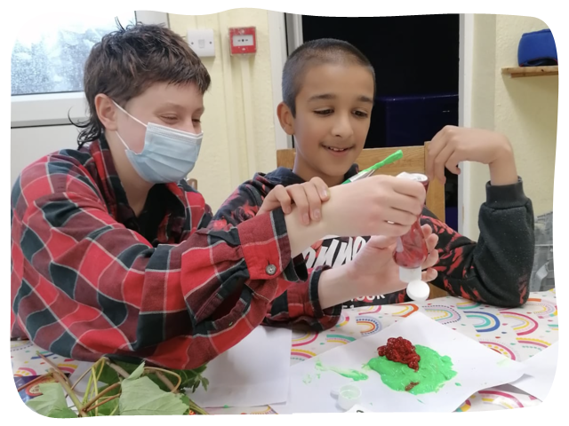 A volunteer in one of our homes helping a resident doing some art